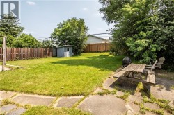 Expansive backyard featuring a lush lawn and a wood privacy fence - 