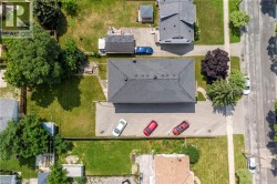 Central building with a dark shingle roof, surrounded by paved parking areas - 