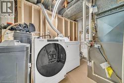 Laundry area with heating unit, finished concrete floors, washing machine and dryer, and gas water heater - 