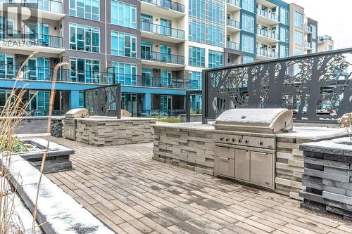 Community BBQ Patio overlooks the Pool Area - 16 Concord Place Unit# 123, Grimsby, ON - Outdoor With Facade