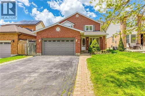 Brick-clad two-story residence featuring an attached garage with a grey panel door - 43 Niska Drive, Waterdown, ON - Outdoor
