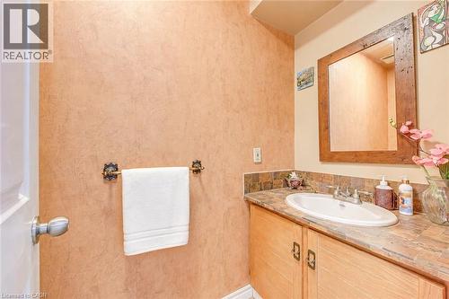 Bathroom vanity featuring a tile countertop, integrated sink, and wood-finish cabinetry - 43 Niska Drive, Waterdown, ON - Indoor Photo Showing Bathroom