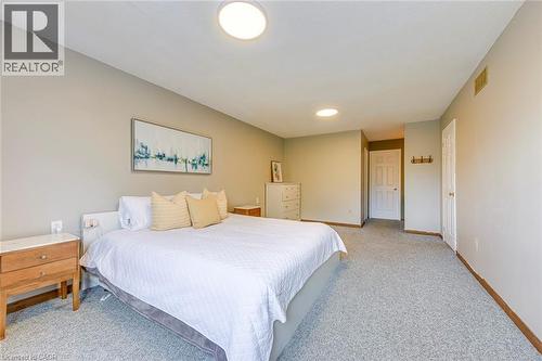 Spacious room featuring neutral wall tones, light gray carpeting, and two overhead flush-mount lighting fixtures - 43 Niska Drive, Waterdown, ON - Indoor Photo Showing Bedroom