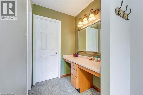 Vanity area featuring a built-in counter with cabinetry, a large framed mirror, and a three-light fixture - 43 Niska Drive, Waterdown, ON - Indoor