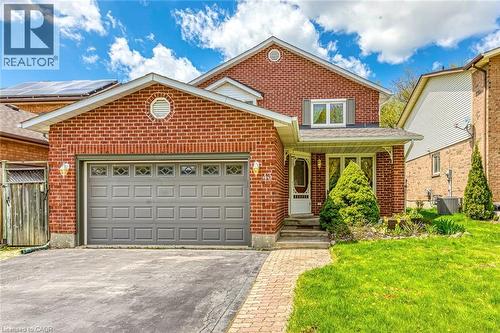 Brick facade residence featuring an attached garage with decorative window inserts, an arched entryway, and a covered porch - 43 Niska Drive, Waterdown, ON - Outdoor
