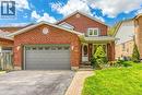 Brick facade residence featuring an attached garage with decorative window inserts, an arched entryway, and a covered porch - 43 Niska Drive, Waterdown, ON  - Outdoor 