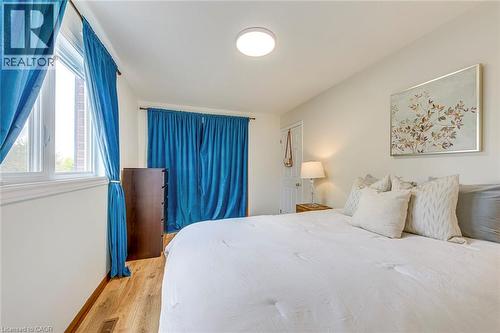 Bright bedroom featuring light-toned walls, wood-finish flooring, and white trim - 43 Niska Drive, Waterdown, ON - Indoor Photo Showing Bedroom
