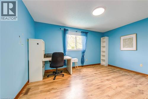 Bright room featuring wood-finish flooring, a window with blue curtains, and a ceiling-mounted light fixture - 43 Niska Drive, Waterdown, ON - Indoor