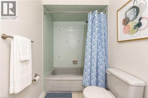 Full bathroom featuring a tub-shower combination with light blue wall tiling and white accent tiles - 43 Niska Drive, Waterdown, ON - Indoor Photo Showing Bathroom
