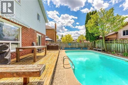 Expansive outdoor living area featuring a rectangular pool, wood deck, and hot tub - 43 Niska Drive, Waterdown, ON - Outdoor With In Ground Pool With Deck Patio Veranda