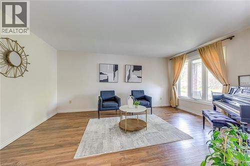 Living area featuring wood-finish flooring, light-toned walls, and a large bay window - 43 Niska Drive, Waterdown, ON - Indoor Photo Showing Living Room