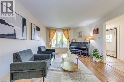 Spacious living area featuring wood-finish flooring, light-toned walls, and a large window with natural light - 43 Niska Drive, Waterdown, ON - Indoor Photo Showing Living Room