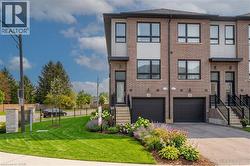 Modern townhome exterior featuring a brick and panel facade, black-framed windows, and a dedicated single-car garage - 