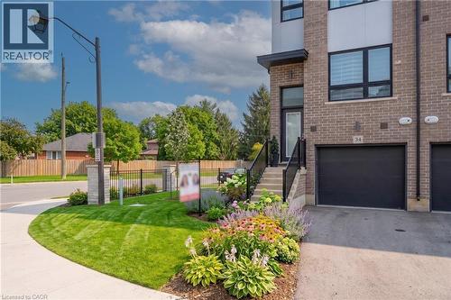 Modern brick townhouse with a black garage door and private entrance - 720 Grey Street Unit# 34, Brantford, ON - Outdoor