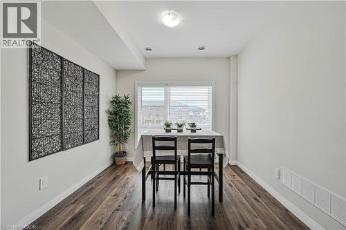 Bright room with wood-finish flooring, white baseboards, and a window with horizontal blinds - 720 Grey Street Unit# 34, Brantford, ON - Indoor Photo Showing Dining Room
