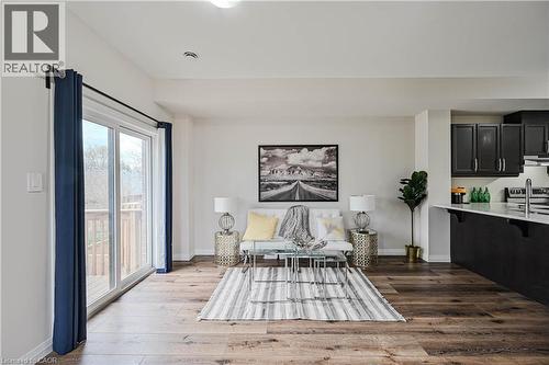 Open-concept living area with wide wood-finish flooring, white walls, and a recessed ceiling light - 720 Grey Street Unit# 34, Brantford, ON - Indoor Photo Showing Bedroom