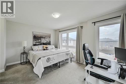 Carpeted bedroom featuring multiple windows, light neutral wall paint, and a flush mount ceiling light fixture - 720 Grey Street Unit# 34, Brantford, ON - Indoor Photo Showing Bedroom