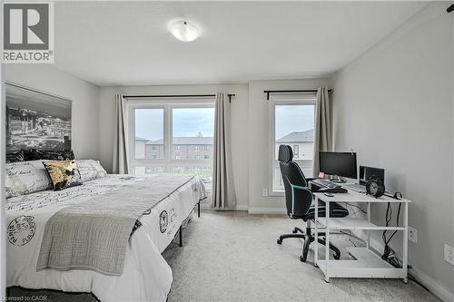 Spacious bedroom featuring light-toned carpeting and multiple windows for abundant natural light - 720 Grey Street Unit# 34, Brantford, ON - Indoor Photo Showing Bedroom