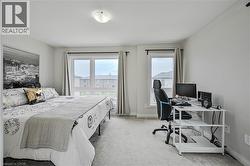 Spacious bedroom featuring light-toned carpeting and multiple windows for abundant natural light - 