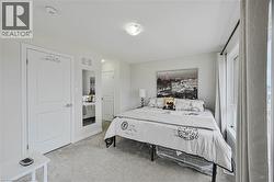 Carpeted room featuring a double-pane window with vertical blinds, a flush-mount ceiling light fixture, and a built-in recessed mirror - 