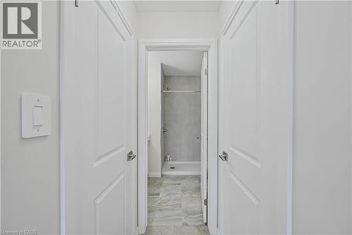 Hallway leading to a bathroom featuring a tile shower surround and a shower/tub combination - 720 Grey Street Unit# 34, Brantford, ON - Indoor Photo Showing Other Room