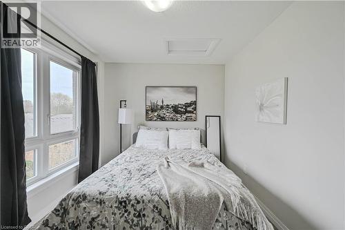 Bright room featuring two large casement windows, light neutral wall paint, and a flush-mount ceiling light fixture - 720 Grey Street Unit# 34, Brantford, ON - Indoor Photo Showing Bedroom