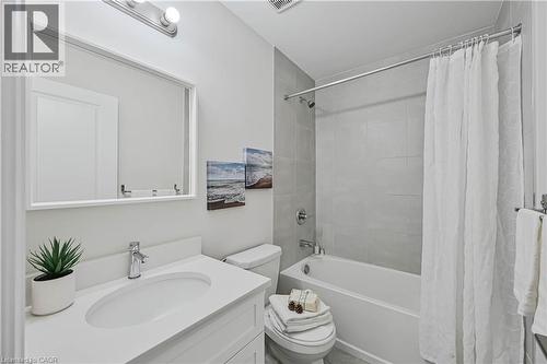 Bathroom featuring a white vanity with an integrated sink, chrome faucet, and rectangular mirror - 720 Grey Street Unit# 34, Brantford, ON - Indoor Photo Showing Bathroom