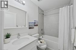 Bathroom featuring a white vanity with an integrated sink, chrome faucet, and rectangular mirror - 