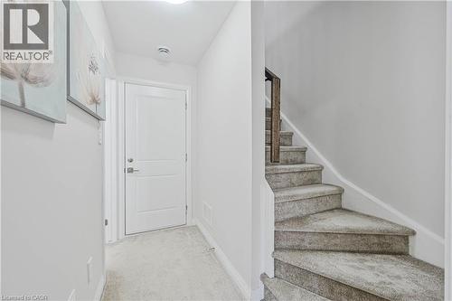 Carpeted staircase featuring a wood-finish handrail - 720 Grey Street Unit# 34, Brantford, ON - Indoor Photo Showing Other Room