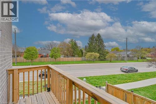 Wood-plank balcony with natural wood railings, overlooking a paved road and sidewalk - 720 Grey Street Unit# 34, Brantford, ON - Outdoor With View