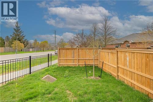 Fenced backyard with green lawn and young tree - 720 Grey Street Unit# 34, Brantford, ON - Outdoor