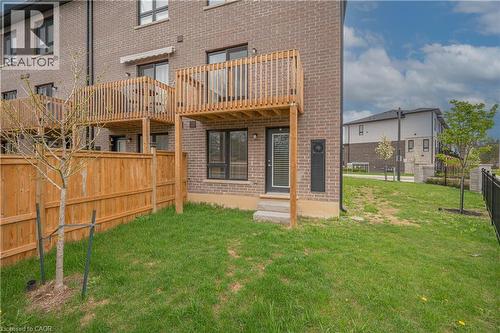 Private backyard featuring a wooden privacy fence and a ground-level exterior door - 720 Grey Street Unit# 34, Brantford, ON - Outdoor With Balcony With Exterior