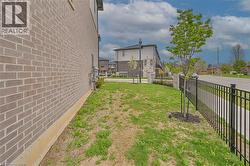 Brick exterior with a black metal fence and established landscaping - 