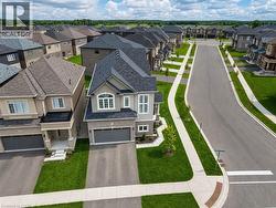 Newly constructed two-story residence featuring a two-car garage, brick and siding facade, arched windows, and a paved driveway - 