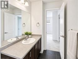 Bathroom vanity featuring an integrated sink, chrome faucet, dark wood-finish cabinetry, and a light-toned countertop - 