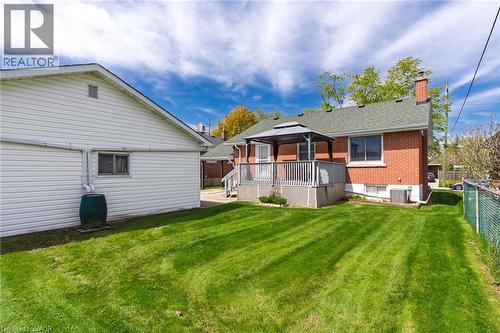 Spacious backyard with manicured lawn, an elevated wood deck, and a detached structure with vinyl siding - 525 East 16Th Street, Hamilton, ON - Outdoor With Deck Patio Veranda With Exterior