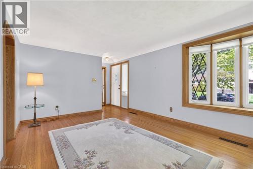 Light wood-finish flooring complements the pastel blue walls in this room - 525 East 16Th Street, Hamilton, ON - Indoor Photo Showing Other Room