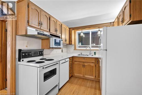 Kitchen featuring wood cabinetry, white countertops, and wood-finish flooring - 525 East 16Th Street, Hamilton, ON - Indoor Photo Showing Kitchen With Double Sink