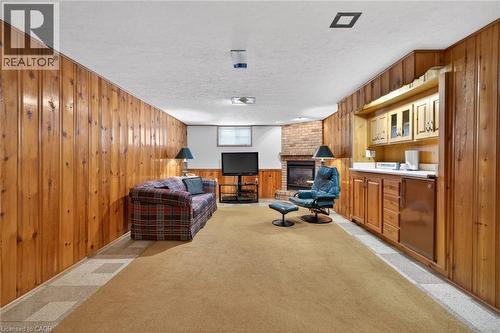 Finished lower level featuring extensive wood paneling, a built-in wet bar with cabinetry, a brick fireplace, and recessed ceiling lighting - 525 East 16Th Street, Hamilton, ON - Indoor