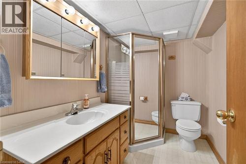 Bathroom featuring a wood-finish vanity with an integrated sink, polished chrome faucet, and mirrored medicine cabinet with vanity lighting - 525 East 16Th Street, Hamilton, ON - Indoor Photo Showing Bathroom