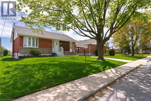 Brick and stone facade residence featuring a front yard with mature landscaping - 525 East 16Th Street, Hamilton, ON - Outdoor