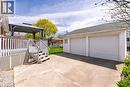 Expansive concrete driveway leading to a detached two-car garage with white panel doors - 525 East 16Th Street, Hamilton, ON  - Outdoor With Exterior 