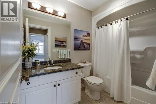 Bathroom featuring a white vanity with paneling, dark speckled countertop, and undermount sink - 605 Welland Avenue Unit# 21, St. Catharines, ON - Indoor Photo Showing Bathroom