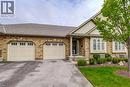 Brick exterior featuring two garage bays with paneled doors and window accents - 605 Welland Avenue Unit# 21, St. Catharines, ON  - Outdoor With Facade 