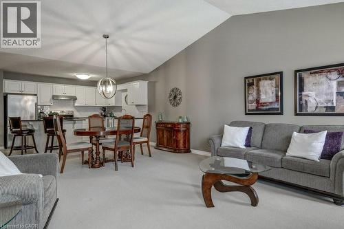 Open-concept living area featuring a vaulted ceiling, light gray wall paint, and plush carpeting - 605 Welland Avenue Unit# 21, St. Catharines, ON - Indoor Photo Showing Living Room