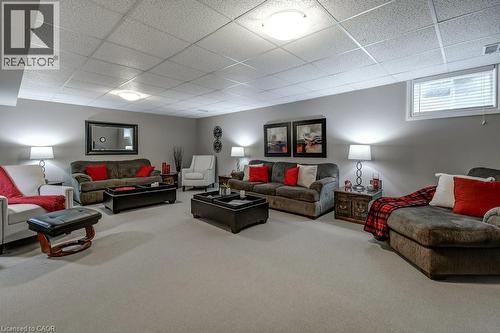 Carpeted lower-level living area featuring neutral wall tones and a grid ceiling - 605 Welland Avenue Unit# 21, St. Catharines, ON - Indoor Photo Showing Basement