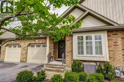 Brick facade residence featuring a covered entry porch, two-car garage, and a prominent bay window - 605 Welland Avenue Unit# 21, St. Catharines, ON - Outdoor