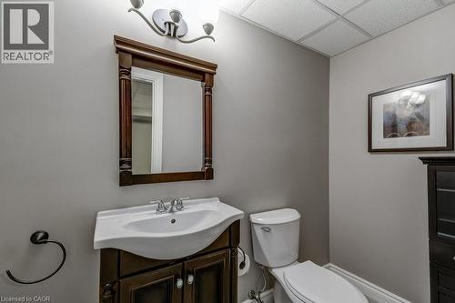 Bathroom featuring a dark wood-finish vanity with an integrated white sink and a chrome faucet - 605 Welland Avenue Unit# 21, St. Catharines, ON - Indoor Photo Showing Bathroom