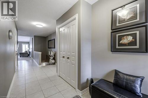Foyer with light-toned tile flooring, neutral wall paint, white trim, and a bi-fold closet - 605 Welland Avenue Unit# 21, St. Catharines, ON - Indoor Photo Showing Other Room