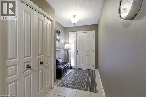 Entryway featuring a paneled door with side lite, light-toned tile flooring, and a built-in closet with bi-fold doors - 605 Welland Avenue Unit# 21, St. Catharines, ON - Indoor Photo Showing Other Room